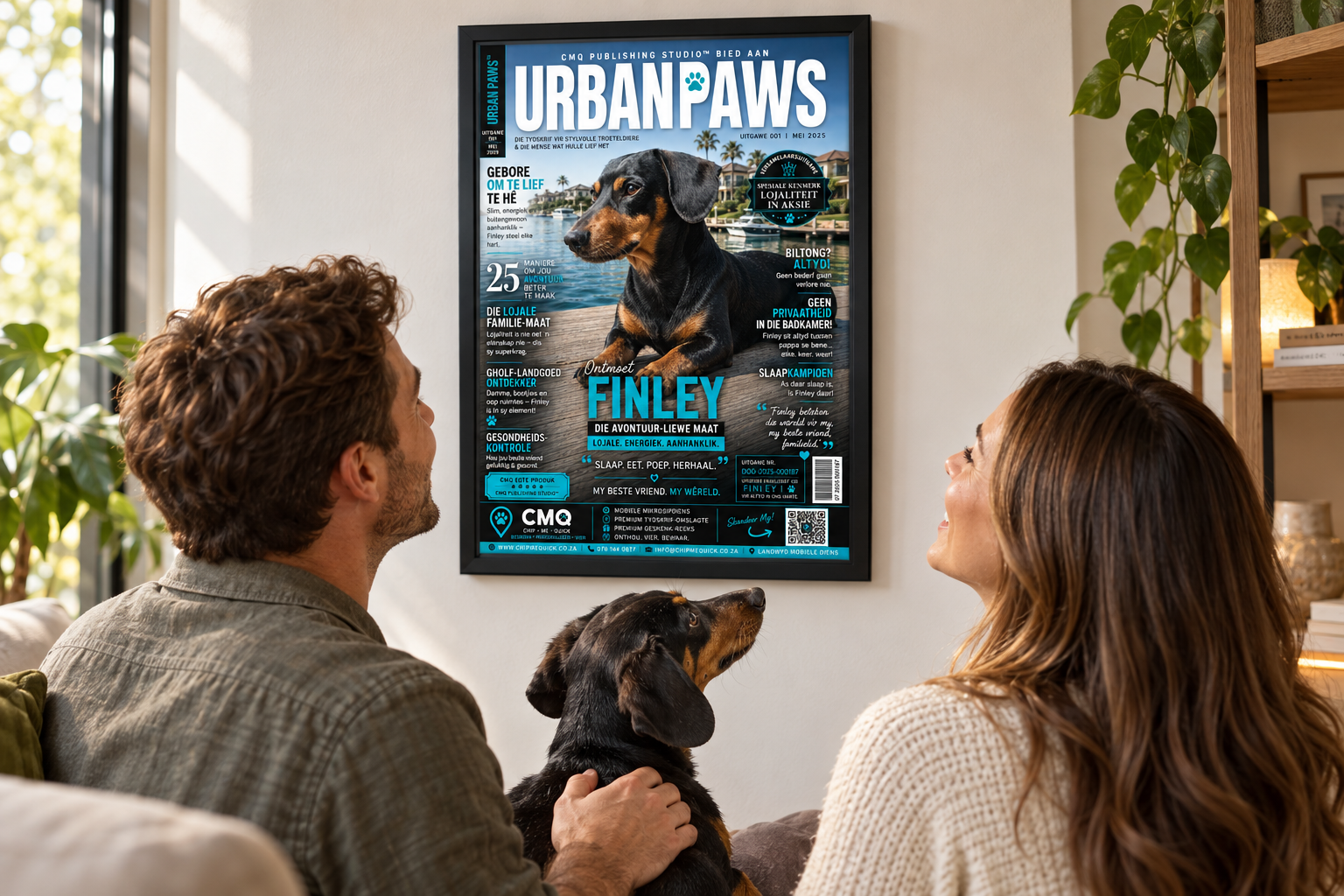 Finley and two happy owners admiring Finley's completed Urban Paws cover mounted in a black A3 aluminium flip frame at home